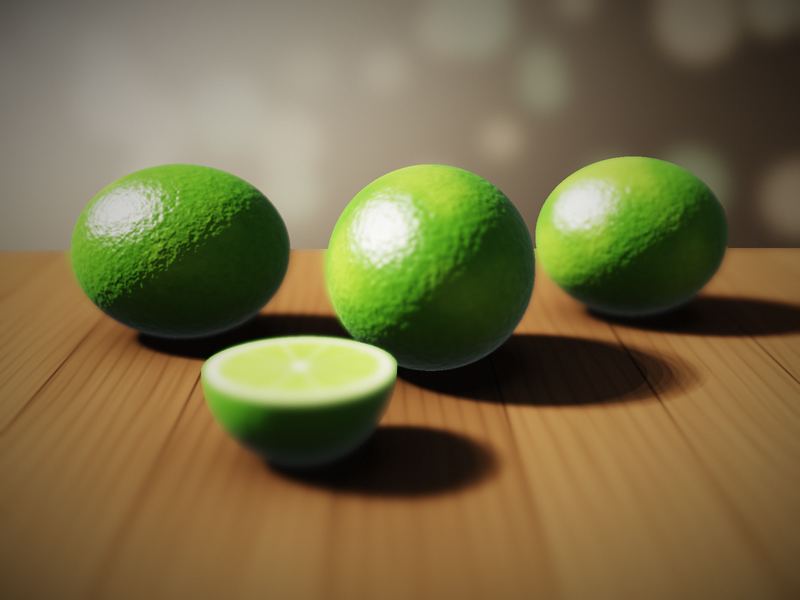 Three whole limes and a cut half on a wooden table, the background softly blurred.